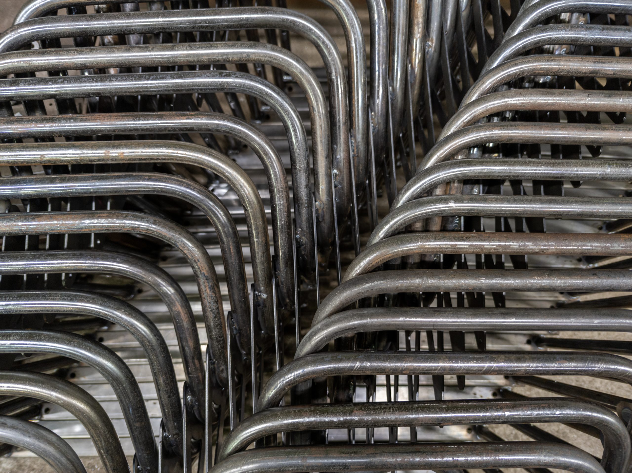 industrial background of bent steel pipes - close-up with selective focus.