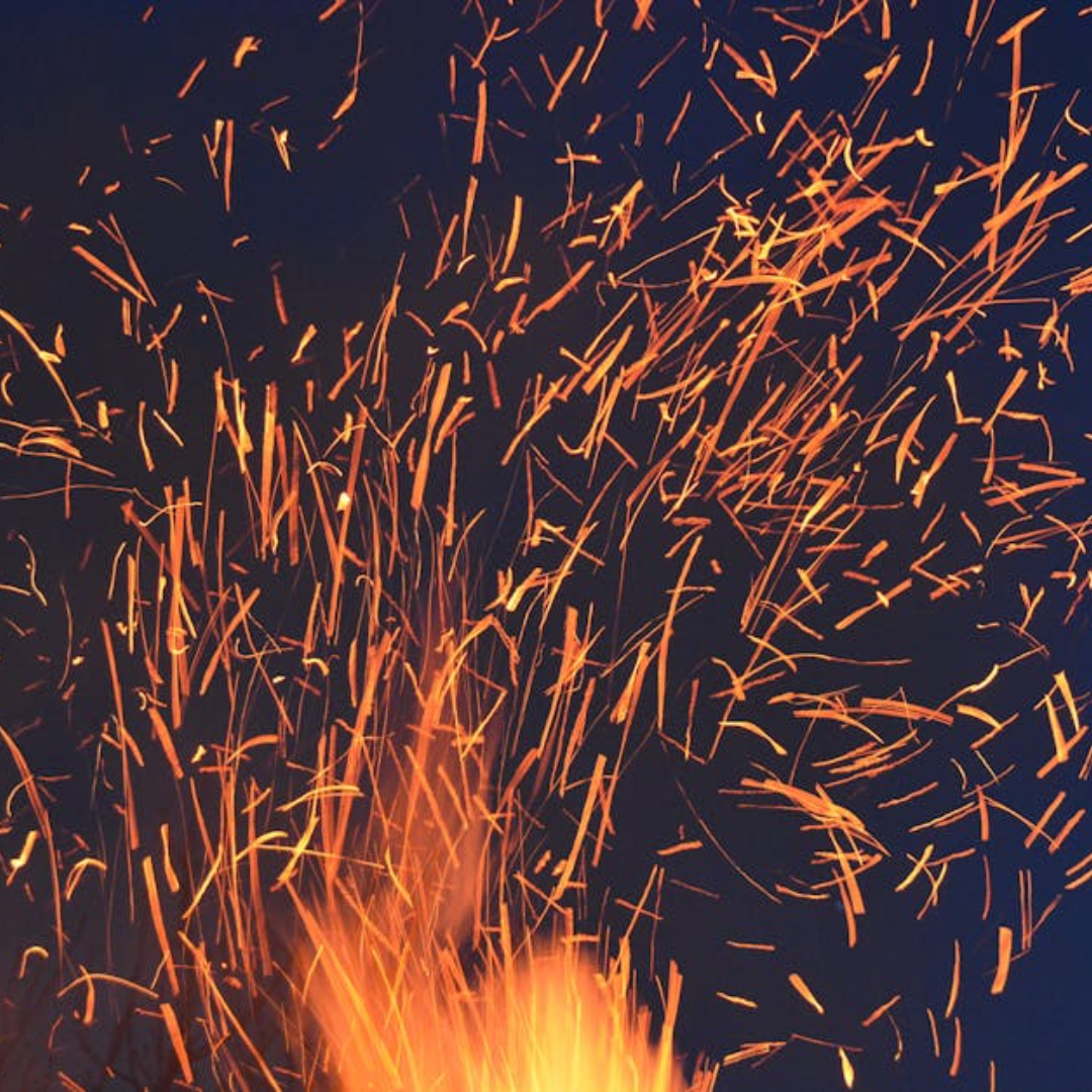 Flame and sparks coming off of a heat exchanger tube being made