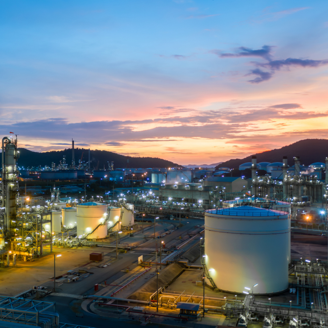 Aerial view oil and gas tank with oil refinery background at night, Glitter lighting of petrochemical plant with night, Manufacturing of petroleum, Products tank in petrochemical plant.