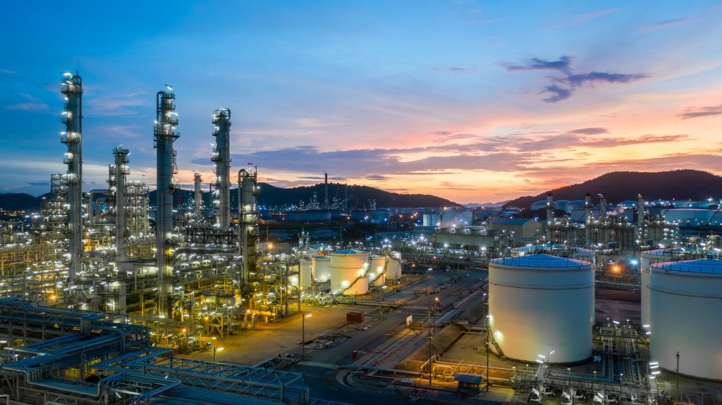 Aerial view oil and gas tank with oil refinery background at night, Glitter lighting of petrochemical plant with night, Manufacturing of petroleum, Products tank in petrochemical plant.